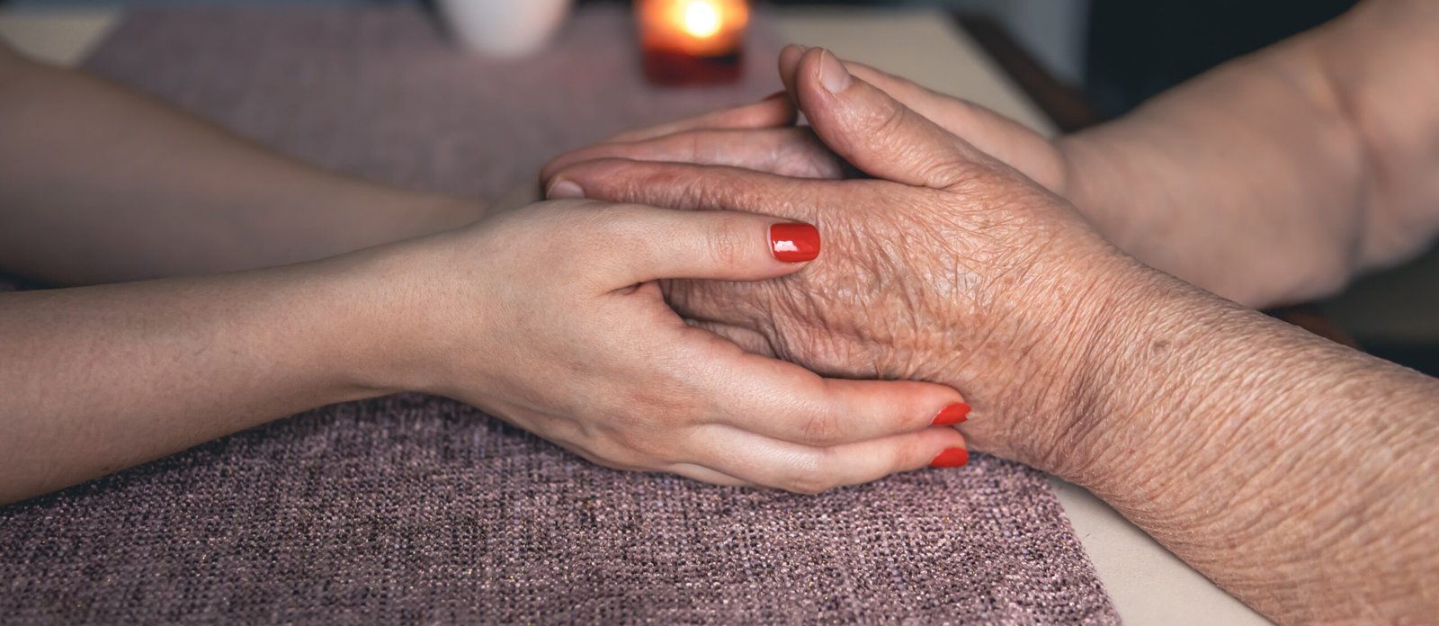old and young man holding hands, close up.